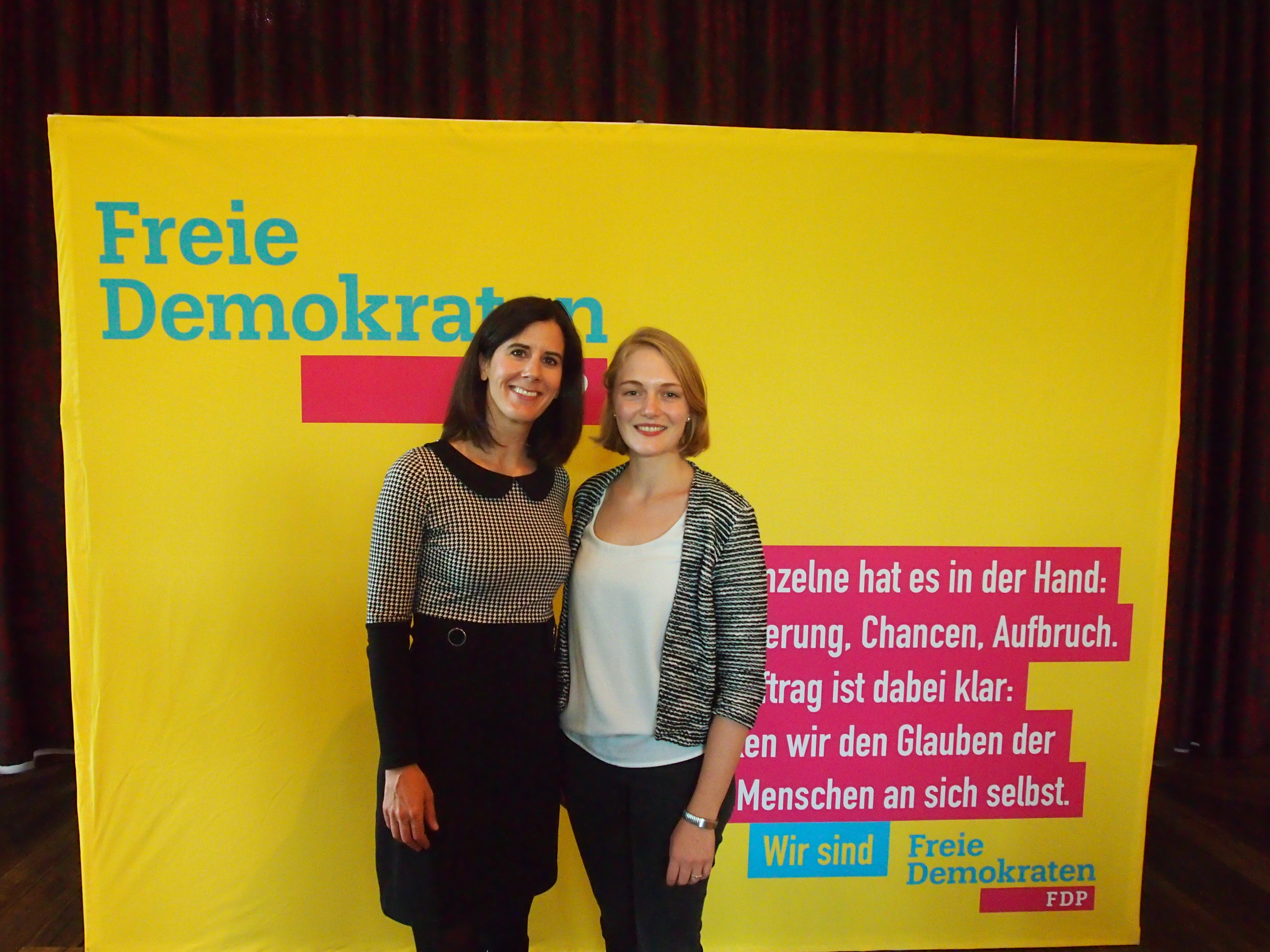 Katja Suding und Ria Schroeder stehen vor einem FDP-Wahlplakat bei der Wahlkreisveranstaltung der FDP Eimsbüttel